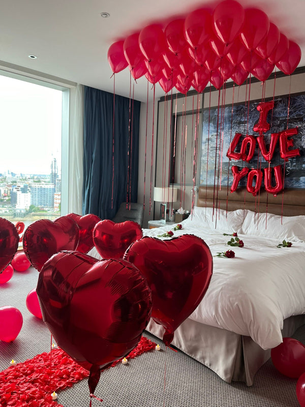 Decorative bedroom with red balloons and 'I LOVE YOU' sign